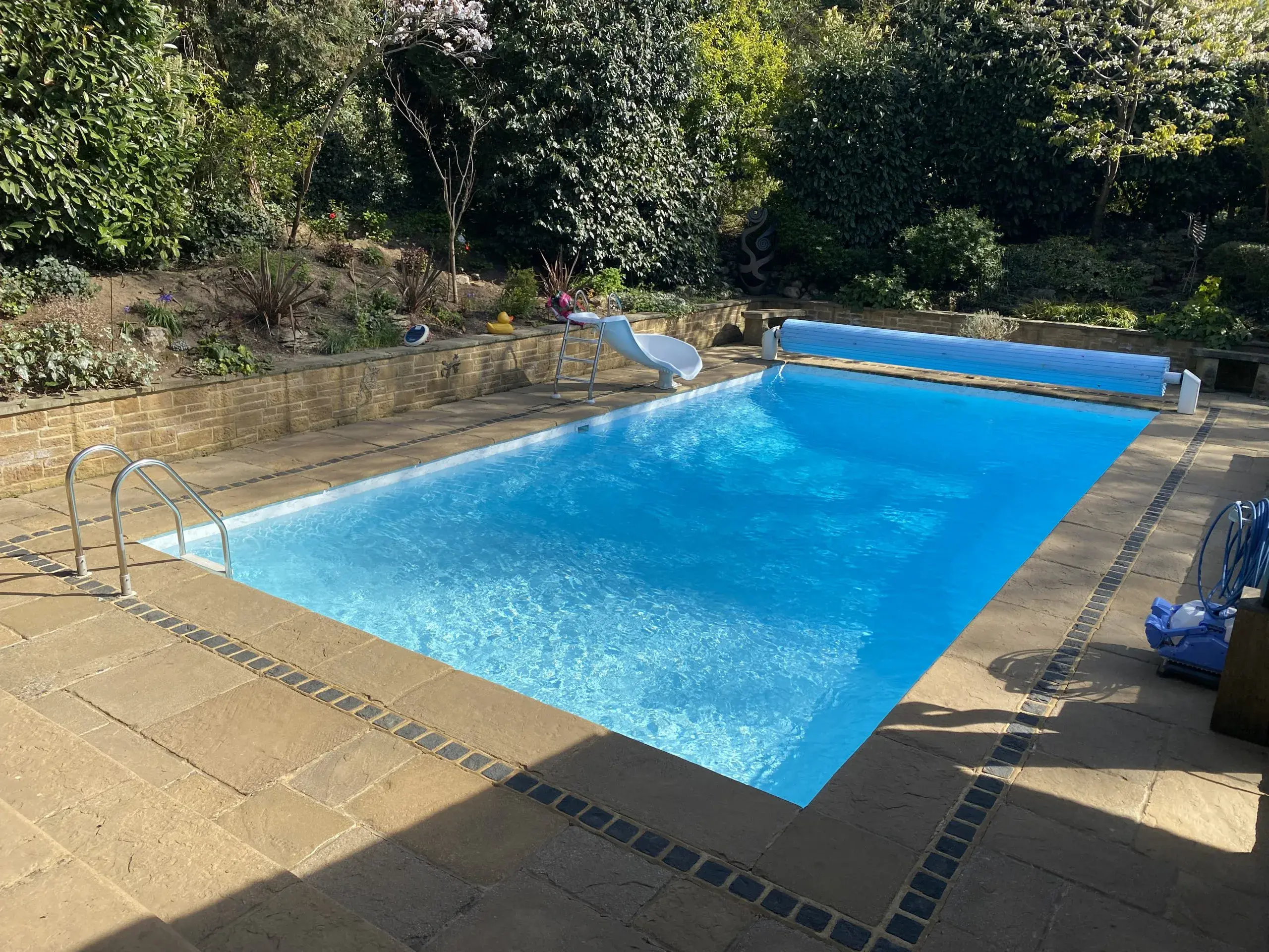 a pool with a slide and trees in the background