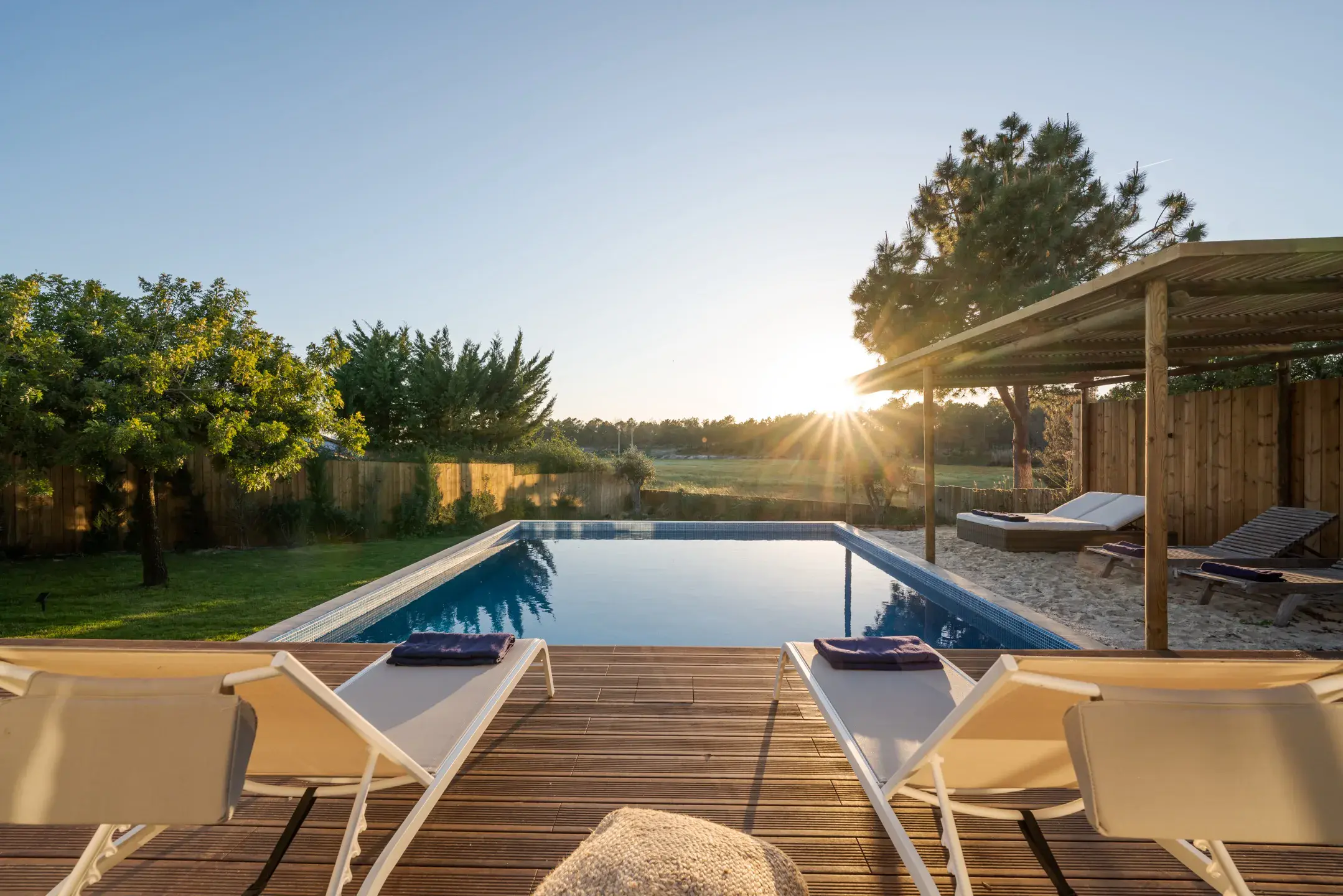 a pool with lounge chairs and a deck